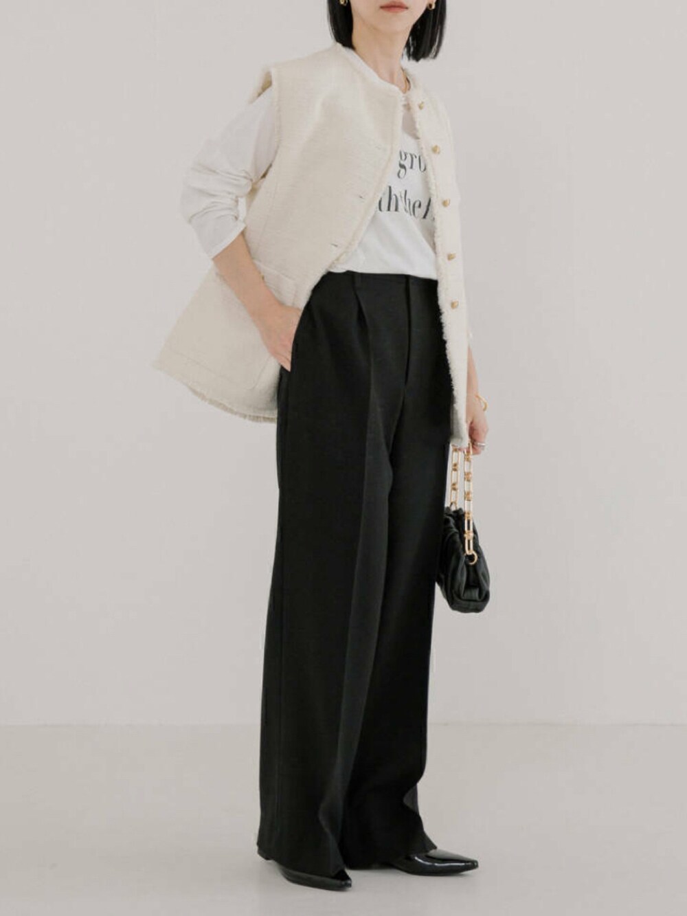 ホワイト系のTシャツ/カットソー、ホワイト系のベスト、ブラック系のその他パンツを着用したレディースの冬コーディネートの2枚目の写真