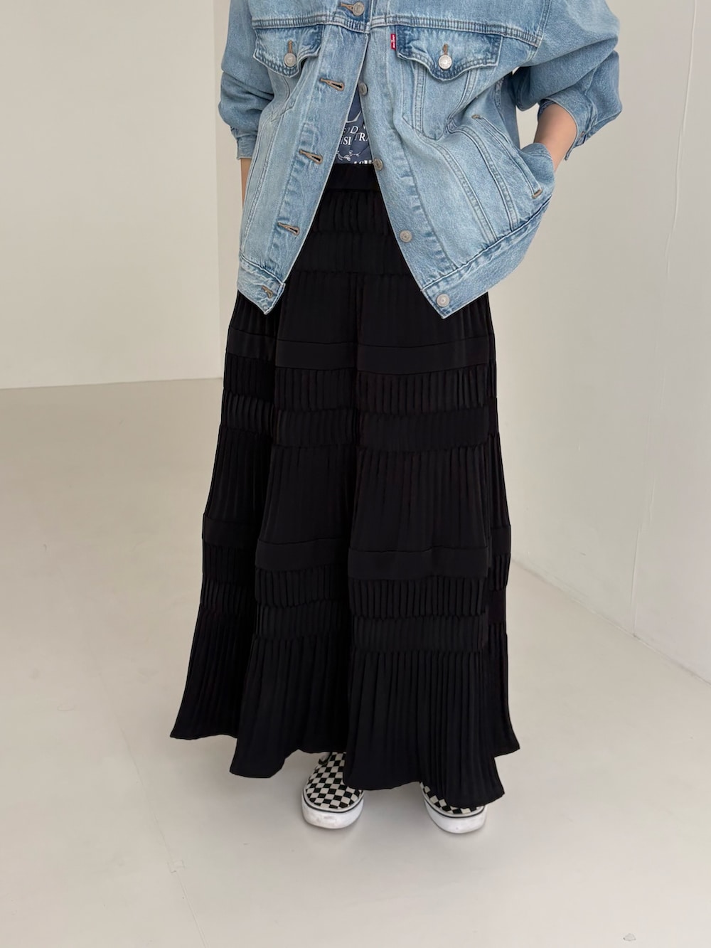 ブルー系のデニムジャケット、ブラウン系のバックパック/リュック、ブラック系のスカートを着用したレディースの春コーディネートの3枚目の写真