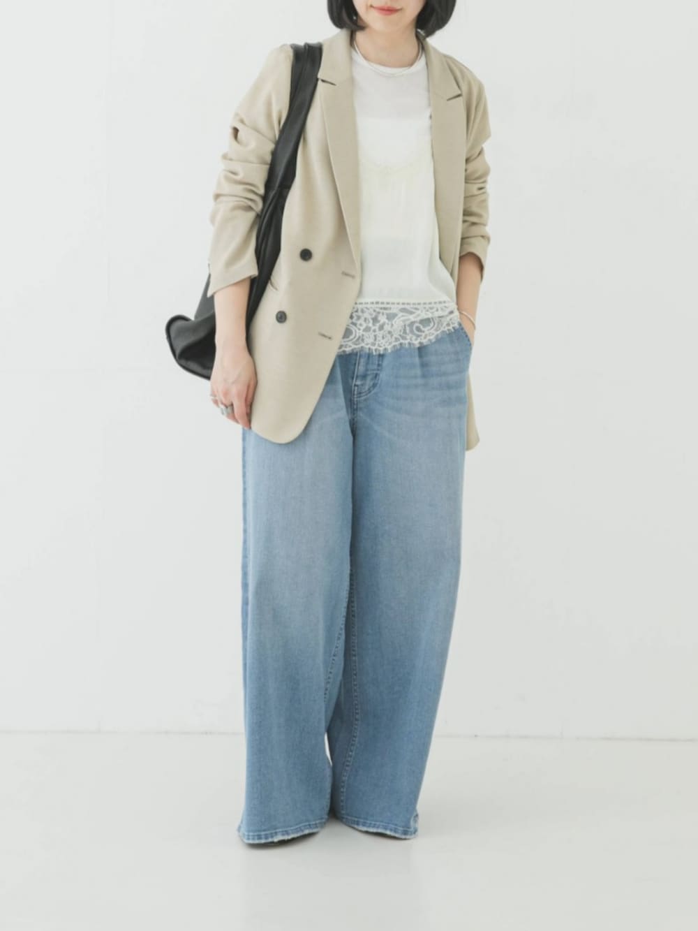 ベージュ系のその他アウター、ブルー系のデニムパンツ、ホワイト系のキャミソールを着用したレディースの春コーディネートの2枚目の写真