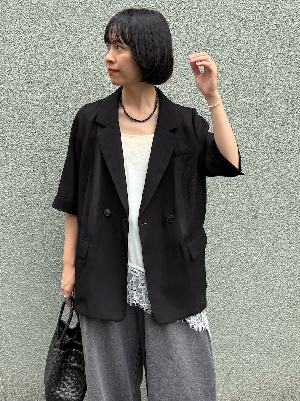 ブラック系のデニムパンツ、ブラック系のトートバッグ、ブラック系のその他アウターを着用したレディースの夏コーディネートの2枚目の写真