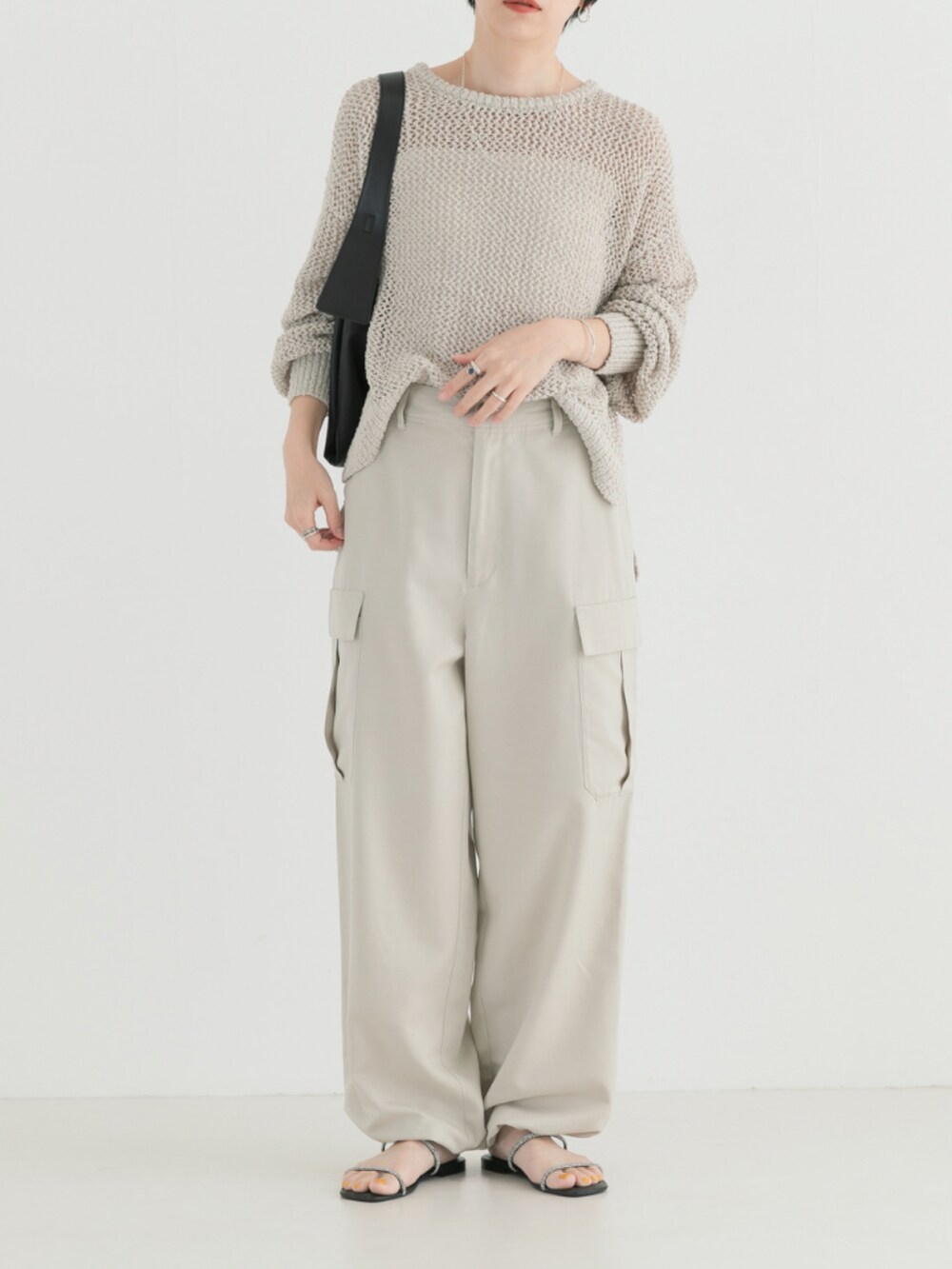 ホワイト系のニット/セーター、ベージュ系のカーゴパンツを着用したレディースの春コーディネートの3枚目の写真