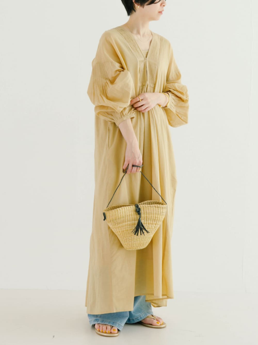 ベージュ系のワンピースを着用したレディースの春コーディネートの3枚目の写真