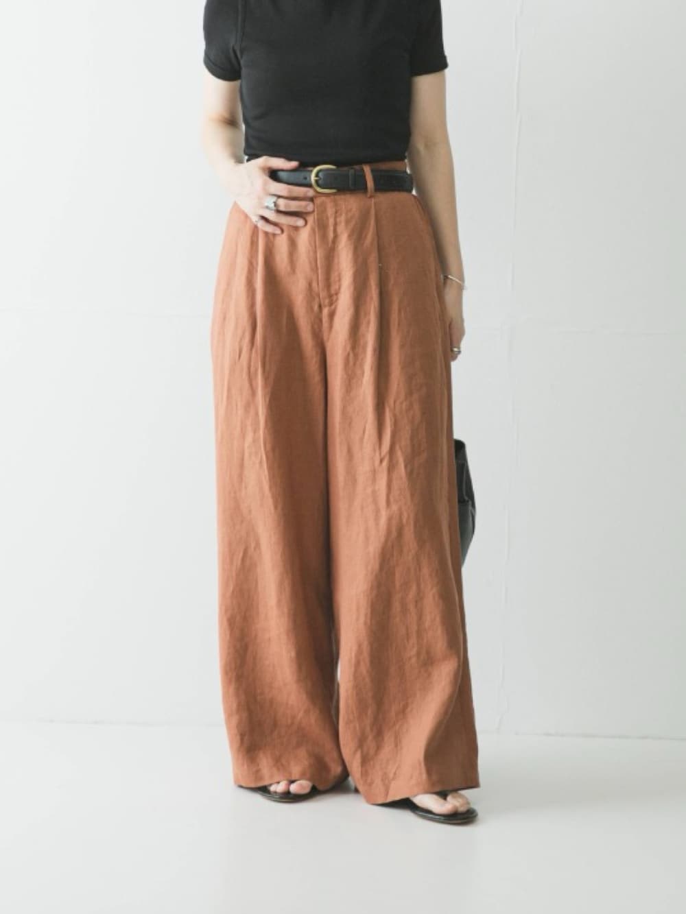 ブラウン系のその他パンツ、ブラック系のハンドバッグ、ブラック系のサンダルを着用したレディースの春コーディネートの3枚目の写真