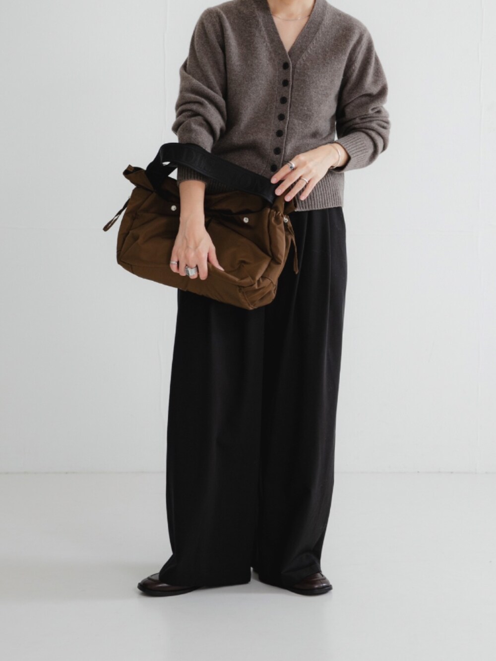 ブラウン系のカーディガン/ボレロ、ブラック系のその他パンツ、ブラウン系のショルダーバッグを着用したレディースの秋コーディネートの4枚目の写真
