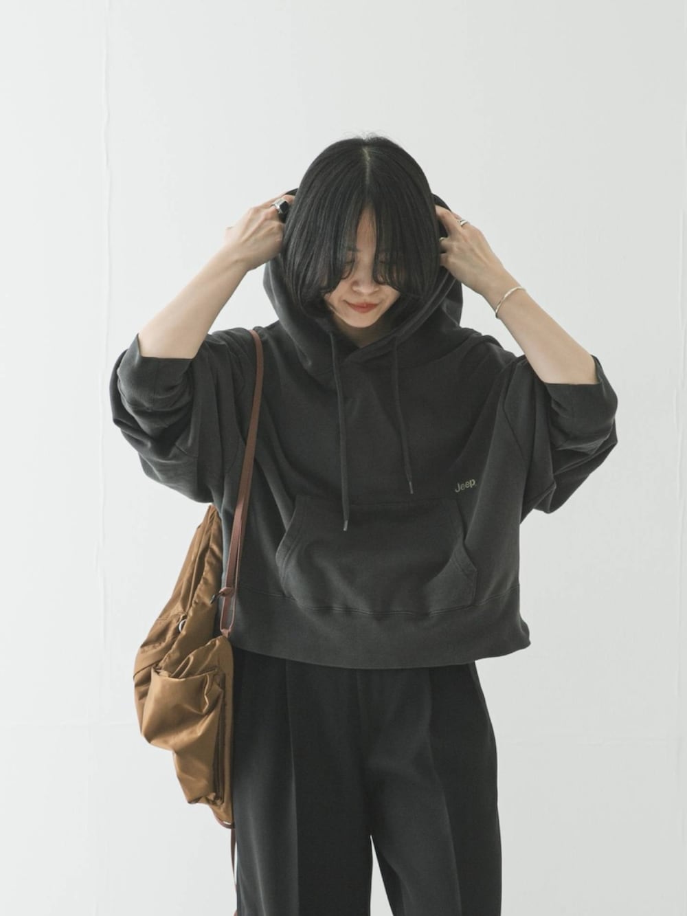 グレー系のパーカー、ブラック系のその他パンツ、ブラック系のパンプスを着用したレディースの春コーディネートの2枚目の写真