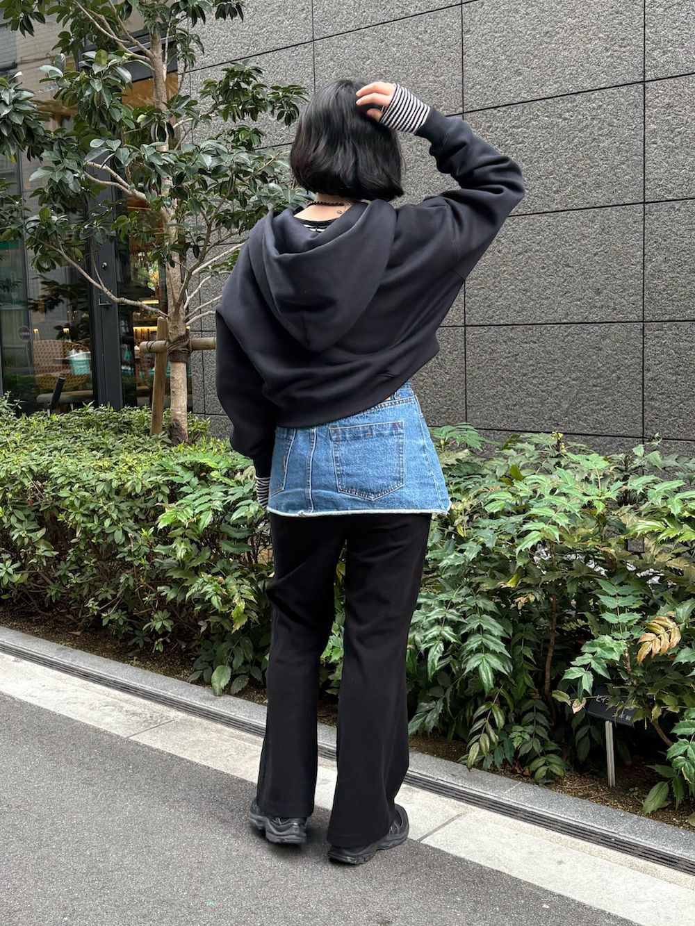 ブラック系のパーカー、ブラック系のスニーカーを着用したレディースの春コーディネートの2枚目の写真