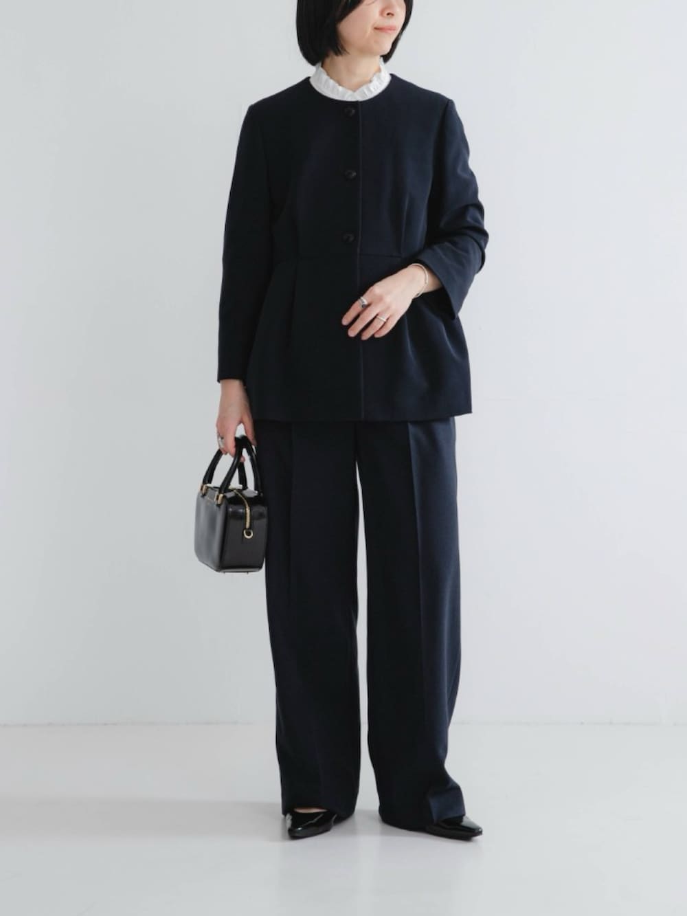 ブルー系のその他パンツ、ブラック系のパンプス、ブルー系のノーカラージャケットを着用したレディースの冬コーディネートの2枚目の写真