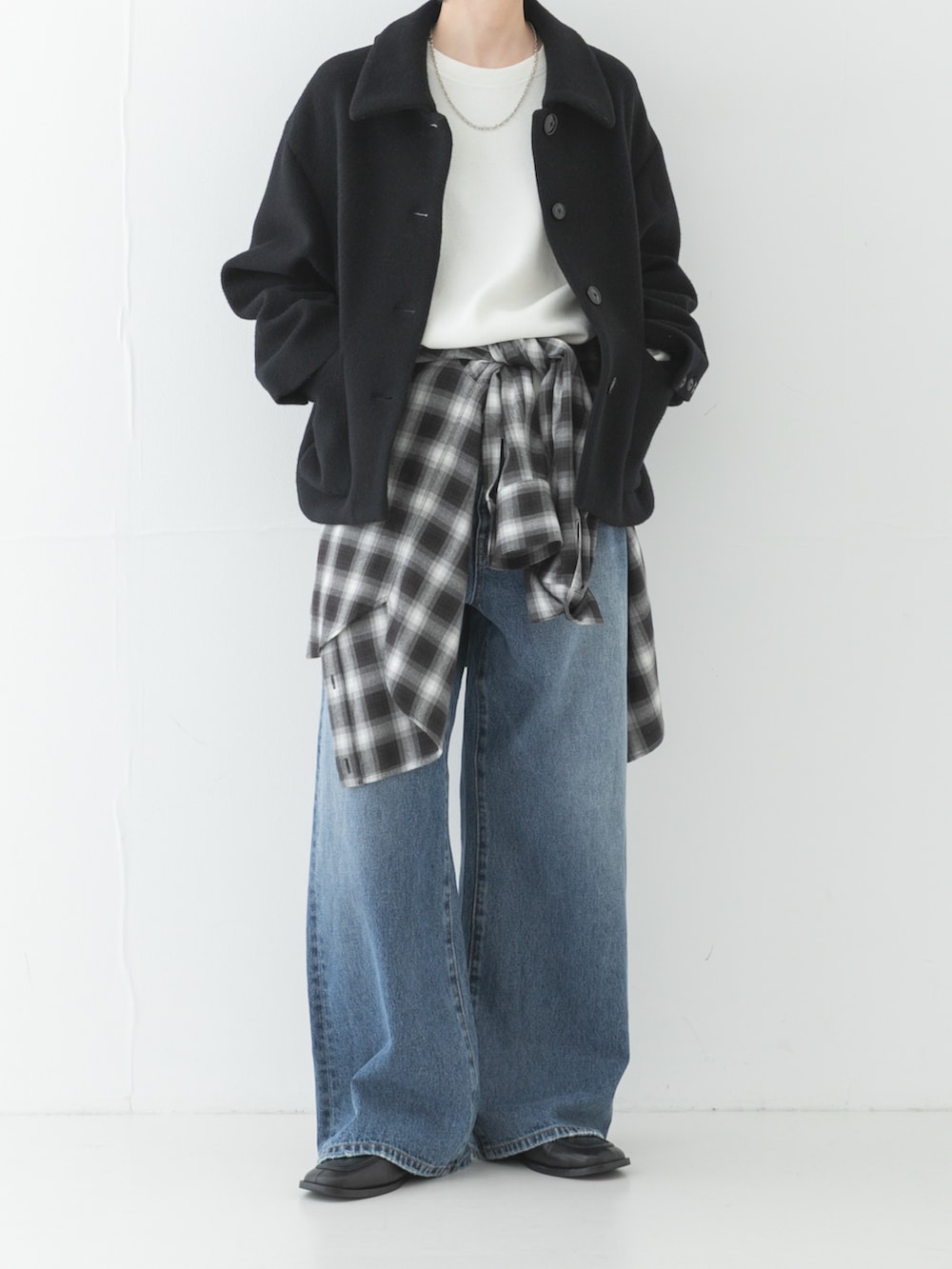 ブラック系のその他アウター、ブルー系のデニムパンツ、ホワイト系のニット/セーターを着用したレディースの秋コーディネートの3枚目の写真