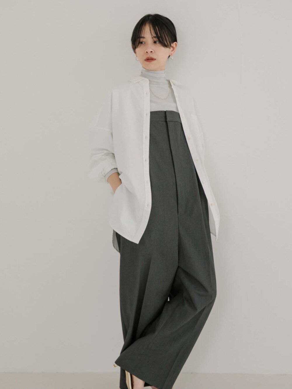 ホワイト系のシャツ/ブラウス、グレー系のサロペット/オーバーオールを着用したレディースの冬コーディネートの2枚目の写真