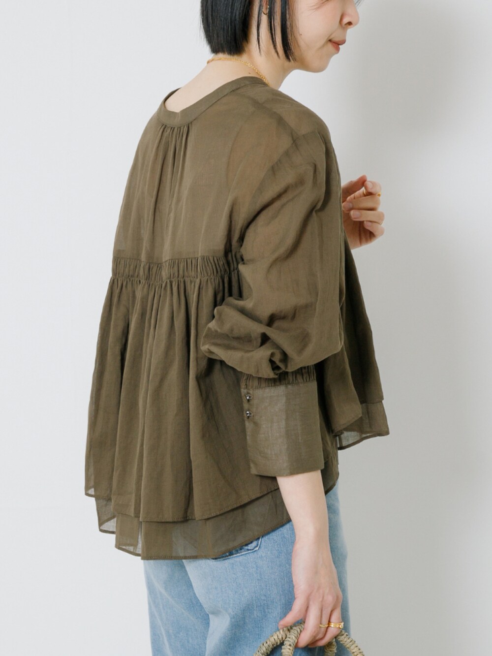 ベージュ系のシャツ/ブラウス、ブルー系のデニムパンツを着用したレディースの春コーディネートの5枚目の写真