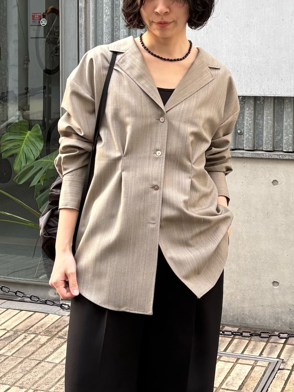 ブラック系のその他パンツ、ブラック系のバックパック/リュック、ベージュ系のシャツ/ブラウスを着用したレディースの冬コーディネートの3枚目の写真