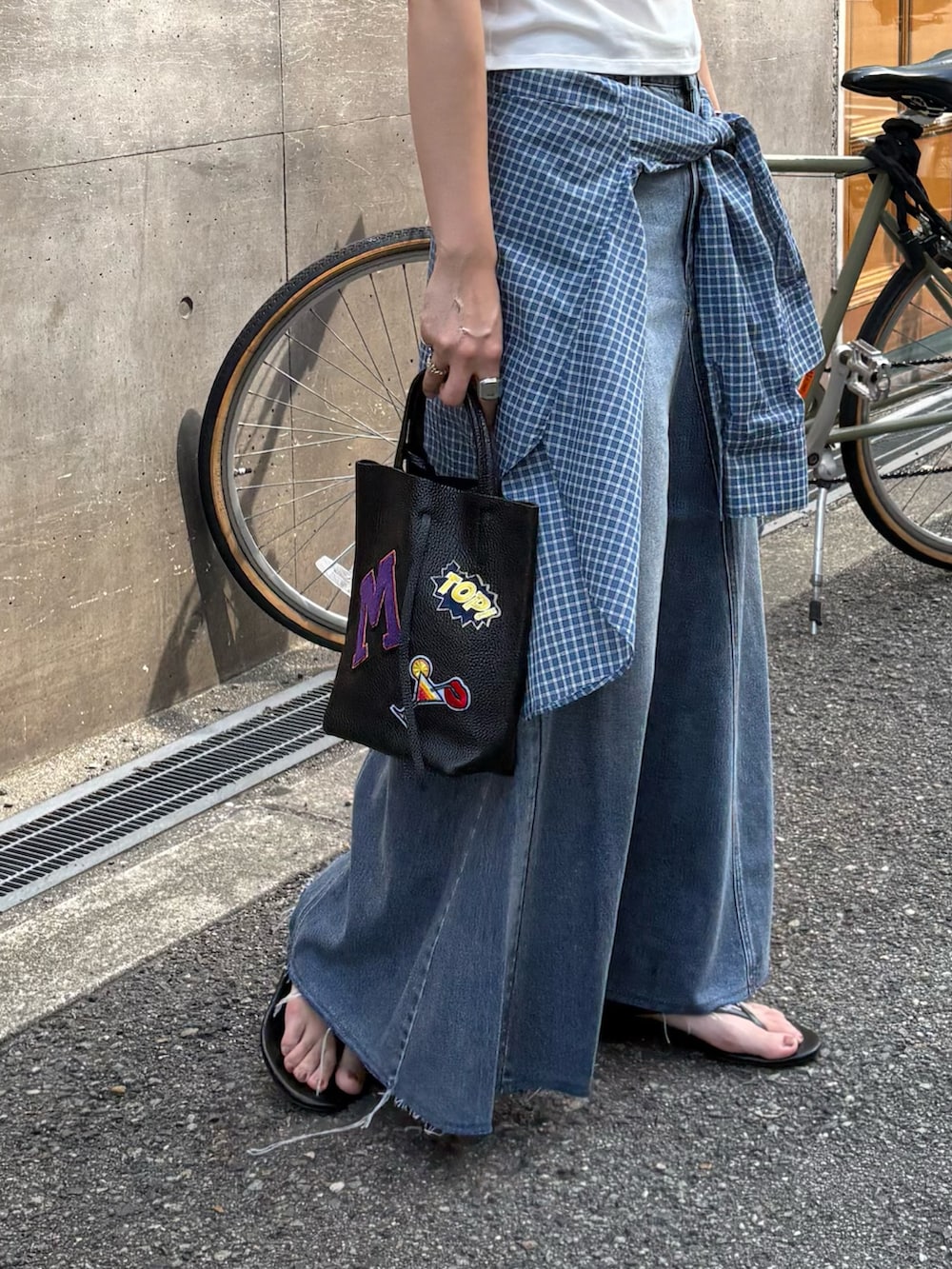 ブルー系のシャツ/ブラウス、ブラック系のトートバッグ、ブルー系のスカートを着用したレディースの夏コーディネートの3枚目の写真