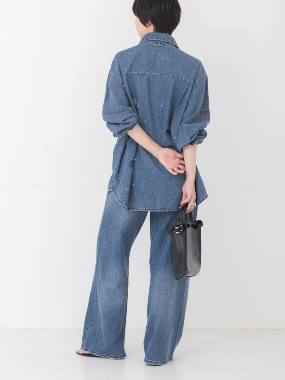 ブルー系のシャツ/ブラウス、ブルー系のデニムパンツ、ブラック系のショルダーバッグを着用したレディースの夏コーディネートの3枚目の写真