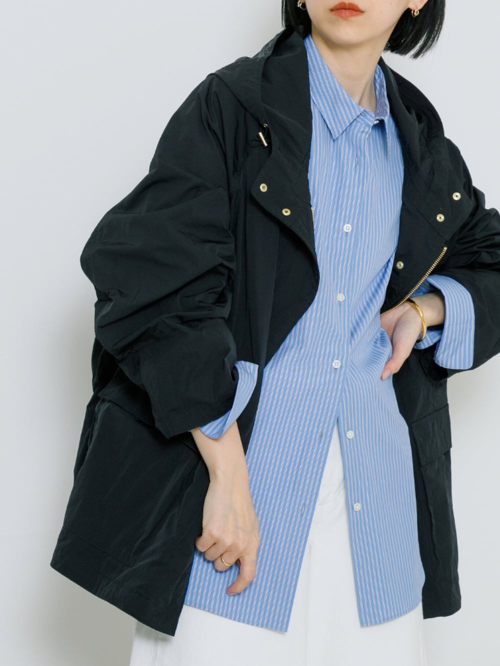 ブラック系のマウンテンパーカー、ホワイト系のデニムパンツ、その他のシャツ/ブラウスを着用したレディースの春コーディネートの2枚目の写真