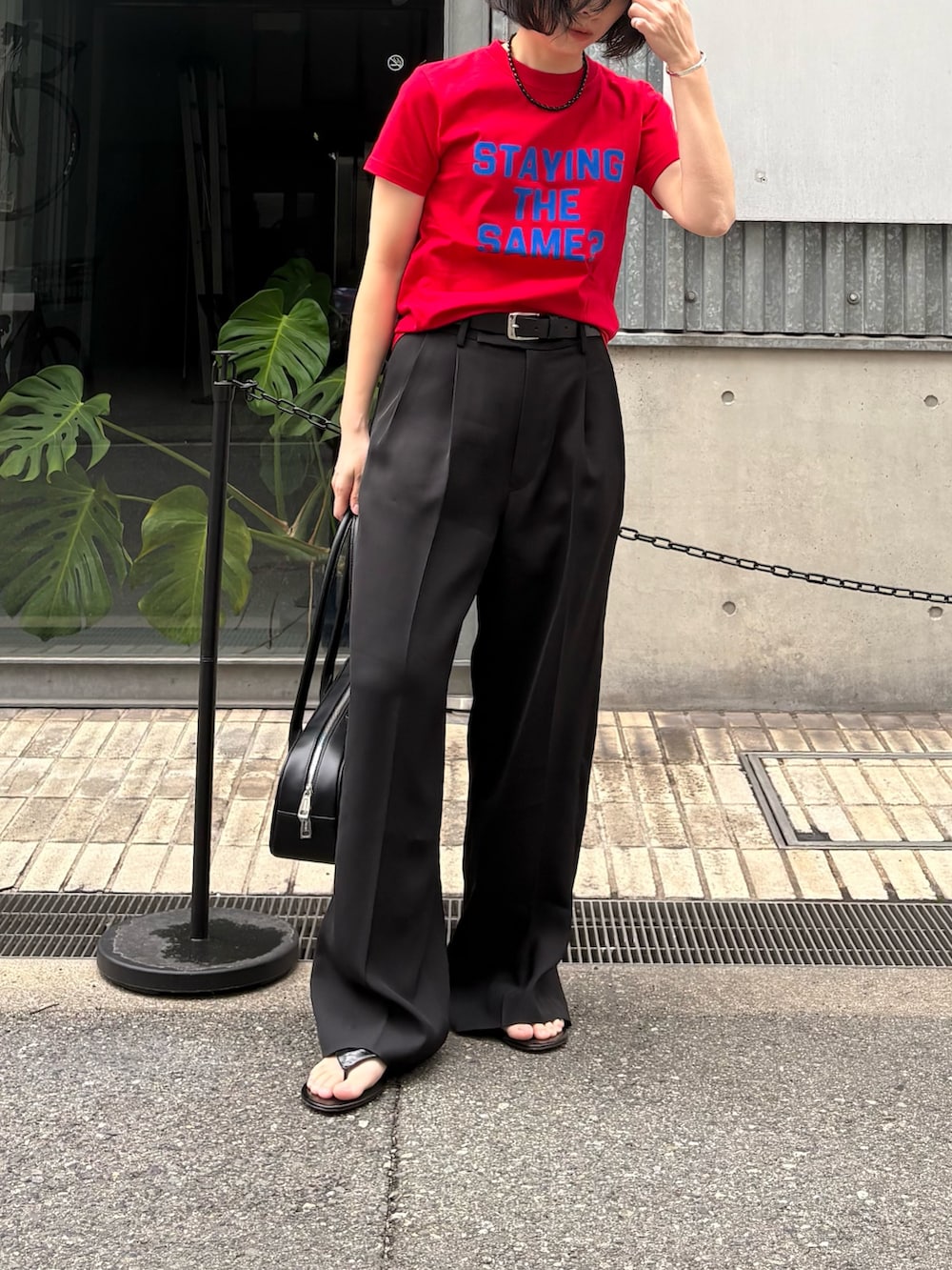 ブラック系のその他パンツ、ブラック系のショルダーバッグ、レッド系のTシャツ/カットソーを着用したレディースの冬コーディネートの5枚目の写真