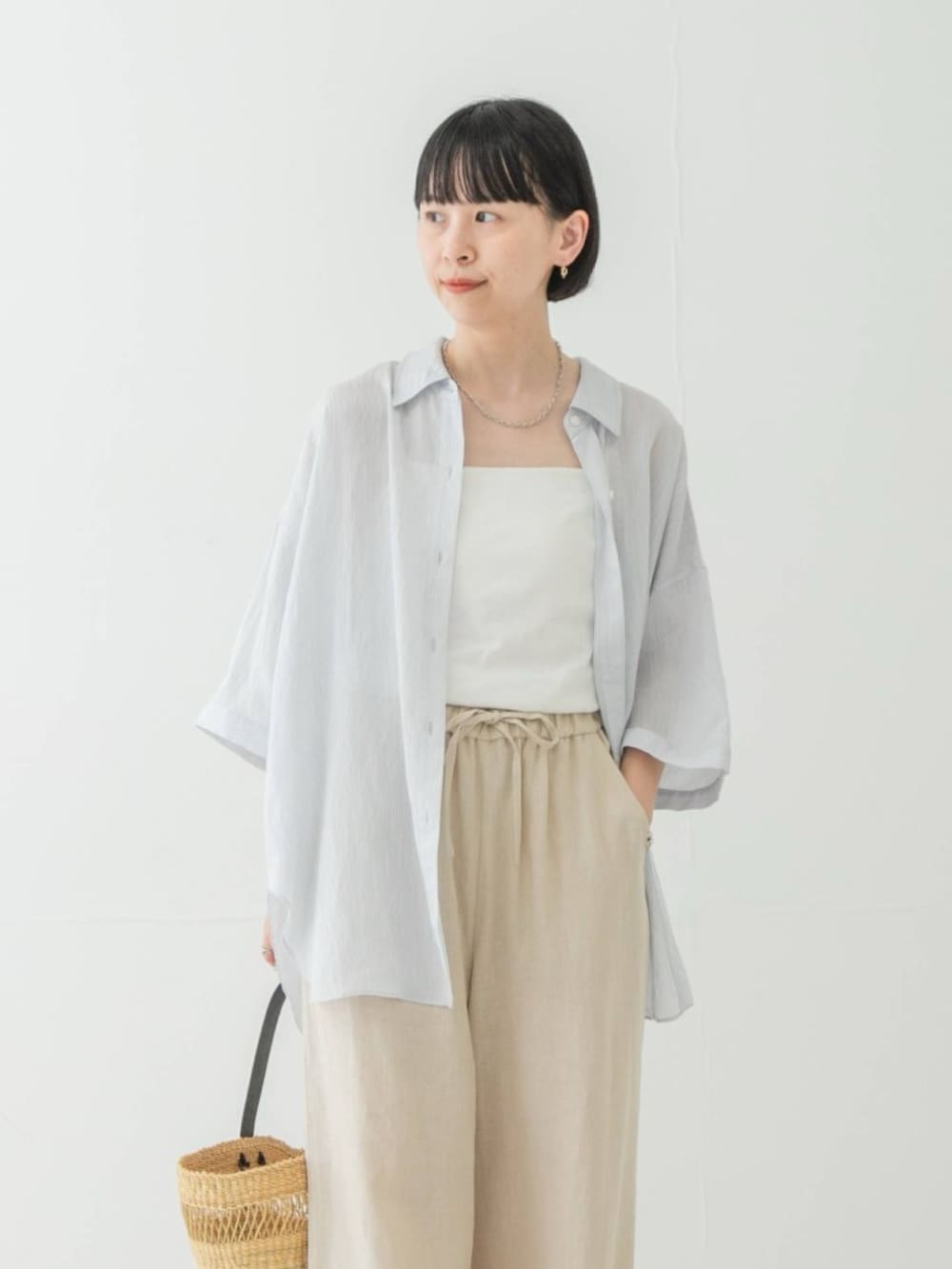 ブルー系のシャツ/ブラウス、ベージュ系のその他パンツ、ベージュ系のかごバッグを着用したレディースの夏コーディネートの2枚目の写真