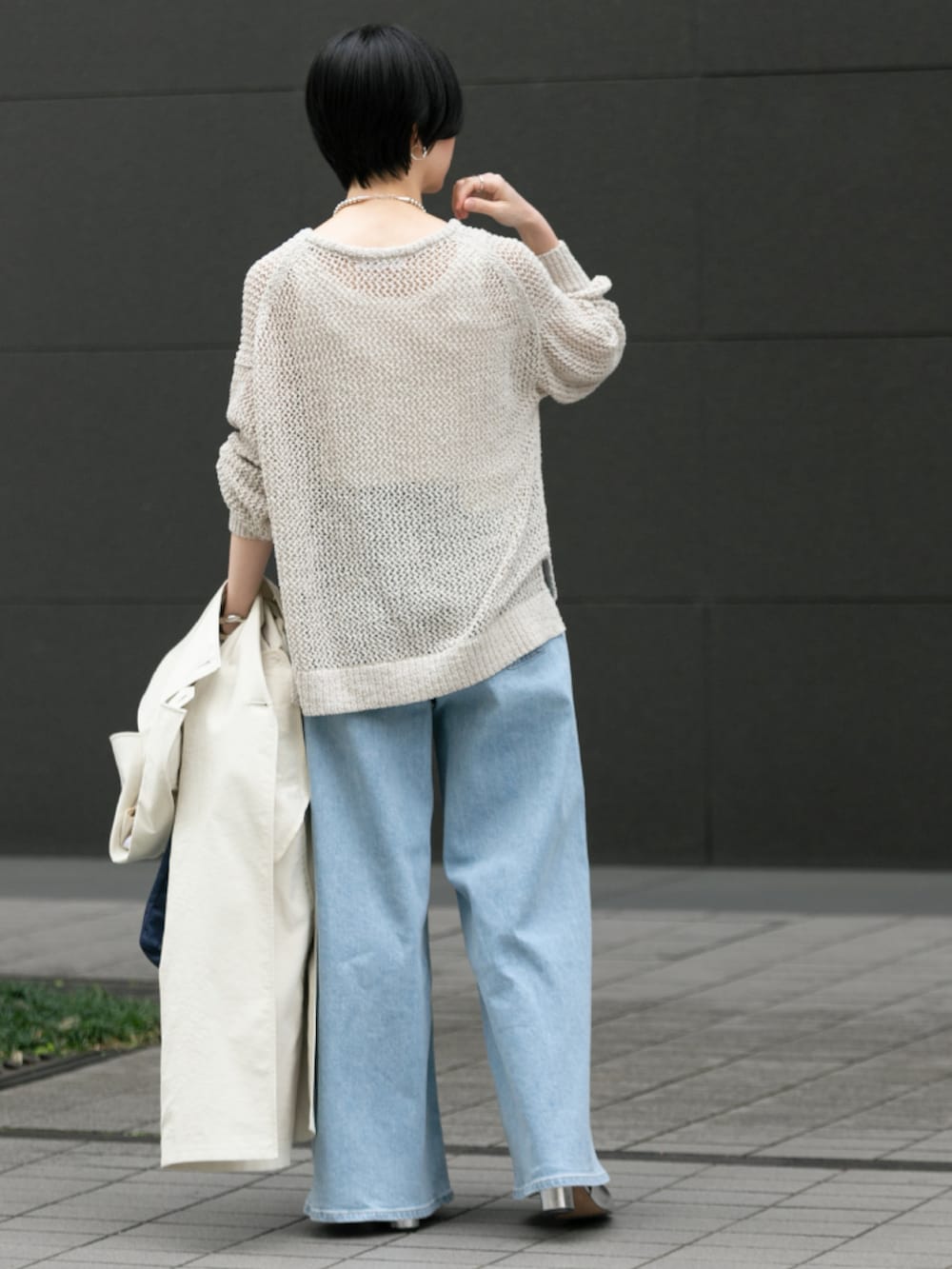 ホワイト系のニット/セーター、ブルー系のデニムパンツ、シルバー系のパンプスを着用したレディースの春コーディネートの3枚目の写真