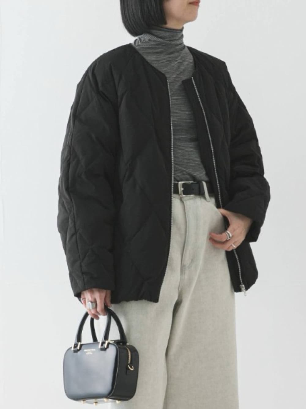 ブラック系のダウンジャケット/コート、ブラック系のTシャツ/カットソー、ブラック系のショルダーバッグを着用したレディースの冬コーディネートの3枚目の写真