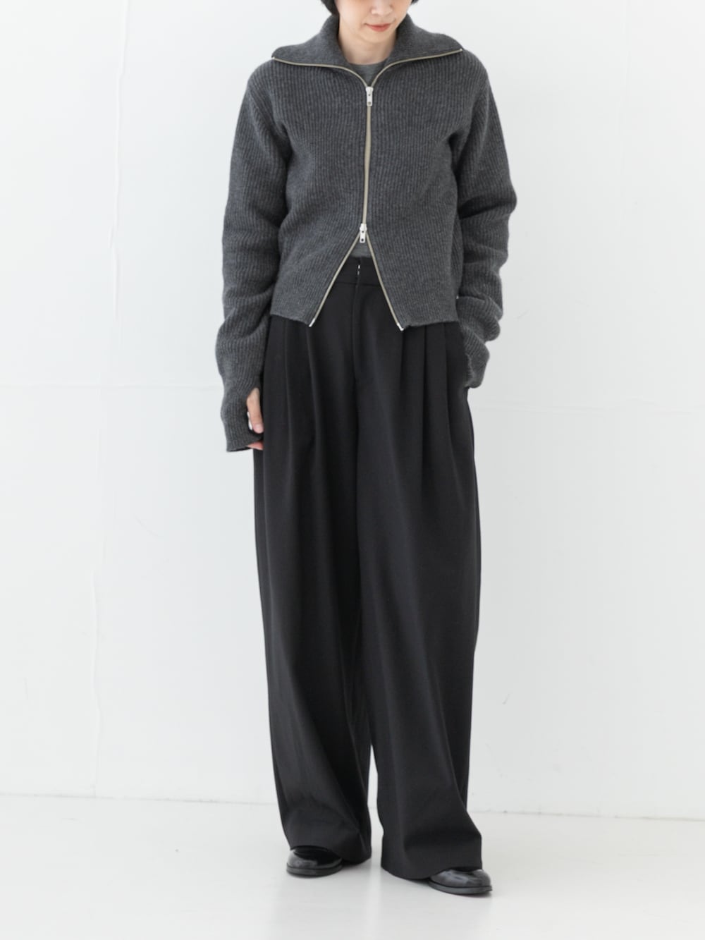 グレー系のニット/セーター、ブラック系のその他パンツ、ブラック系のTシャツ/カットソーを着用したレディースの秋コーディネートの3枚目の写真