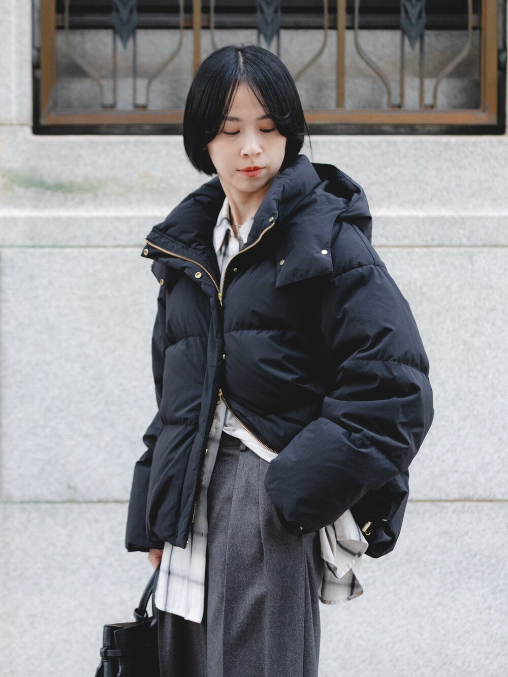 ブラック系のダウンジャケット/コート、ホワイト系のシャツ/ブラウス、グレー系のその他パンツを着用したレディースの秋コーディネートの4枚目の写真