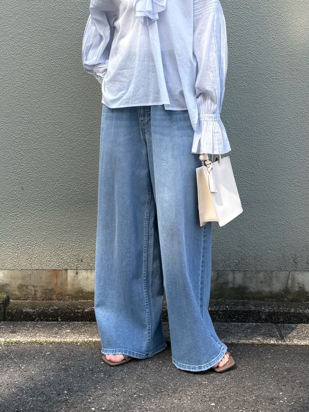 ブルー系のシャツ/ブラウス、ブルー系のデニムパンツ、ホワイト系のハンドバッグを着用したレディースの春コーディネートの4枚目の写真