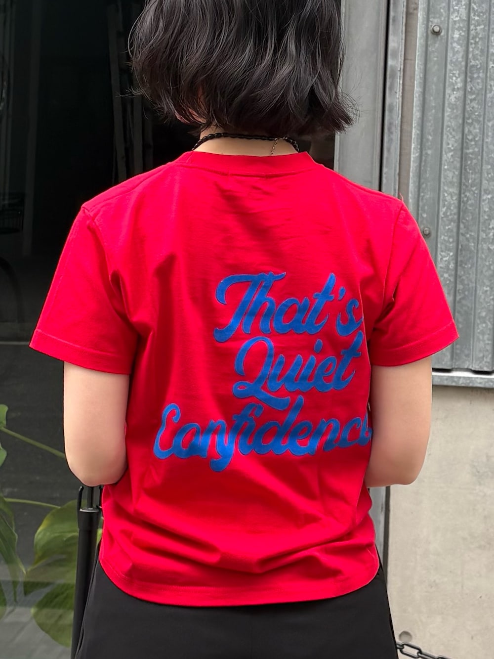 ブラック系のその他パンツ、ブラック系のショルダーバッグ、レッド系のTシャツ/カットソーを着用したレディースの冬コーディネートの3枚目の写真