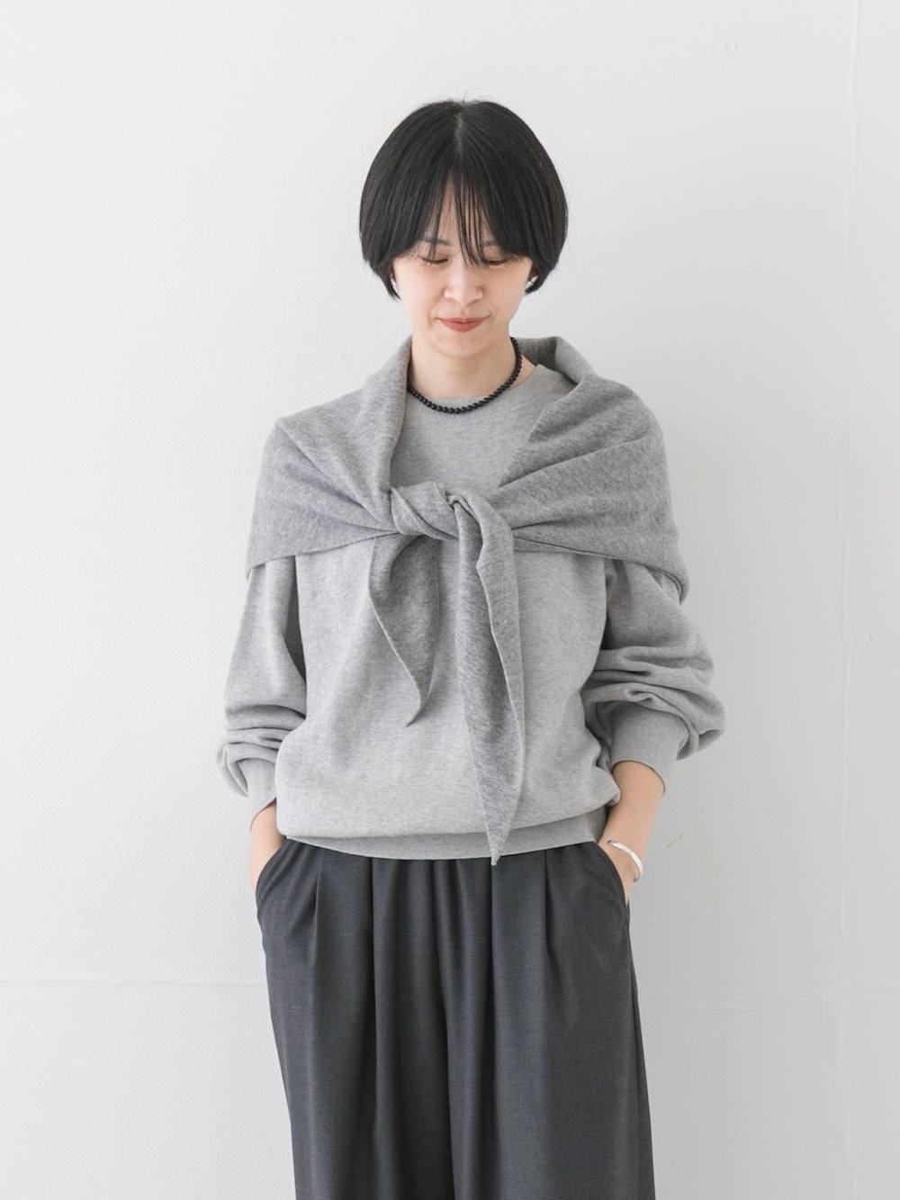 グレー系のスニーカー、グレー系のニット/セーター、グレー系のその他パンツを着用したレディースの夏コーディネートの2枚目の写真