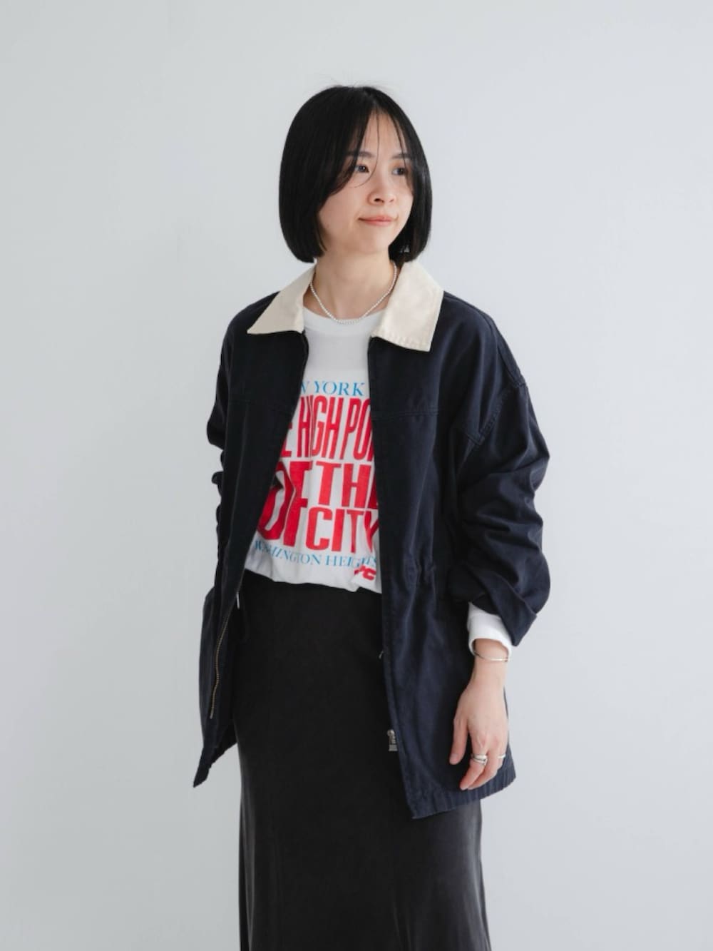 ブルー系のカバーオール、ホワイト系のTシャツ/カットソー、ブラック系のスカートを着用したレディースの冬コーディネートの3枚目の写真