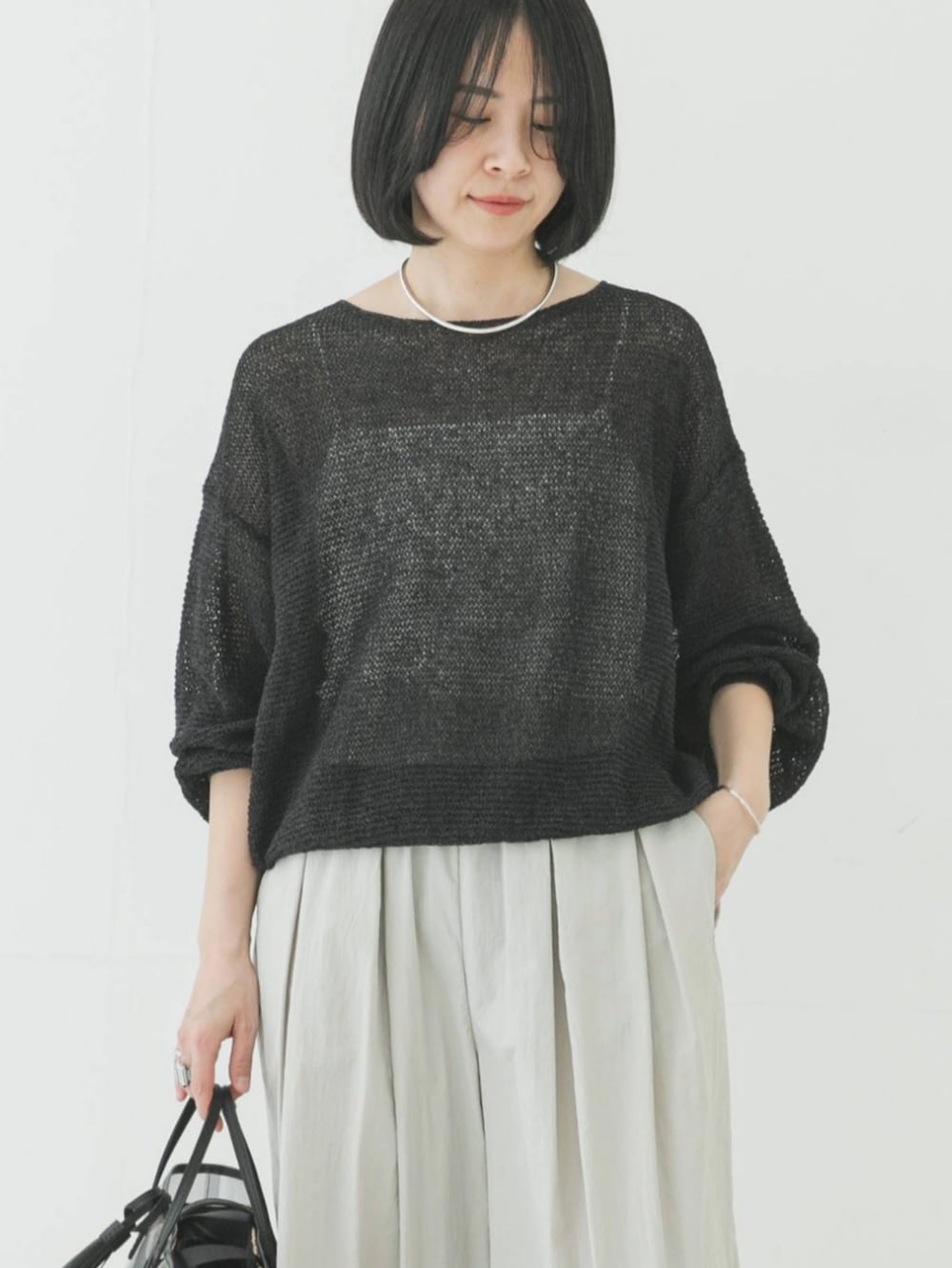 グレー系のニット/セーター、グレー系のその他パンツを着用したレディースの春コーディネートの2枚目の写真