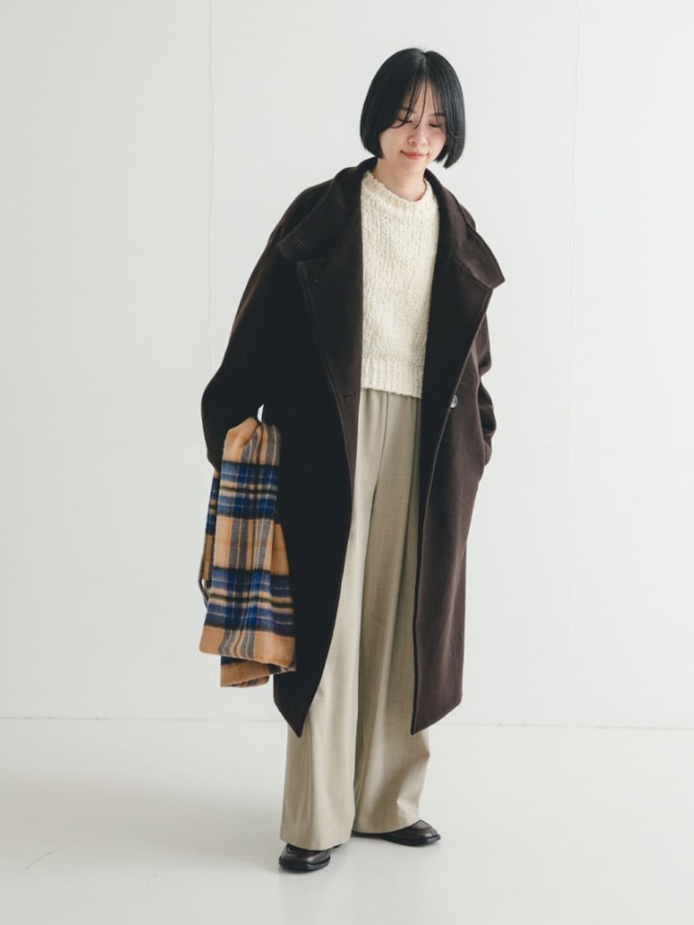 ホワイト系のニット/セーター、ブラウン系のその他アウター、ベージュ系のその他パンツを着用したレディースの冬コーディネートの2枚目の写真