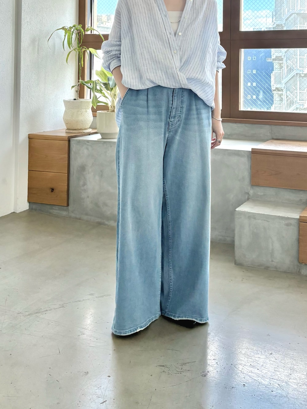 ブルー系のシャツ/ブラウス、ブルー系のデニムパンツ、ブラック系のパンプスを着用したレディースの冬コーディネートの3枚目の写真