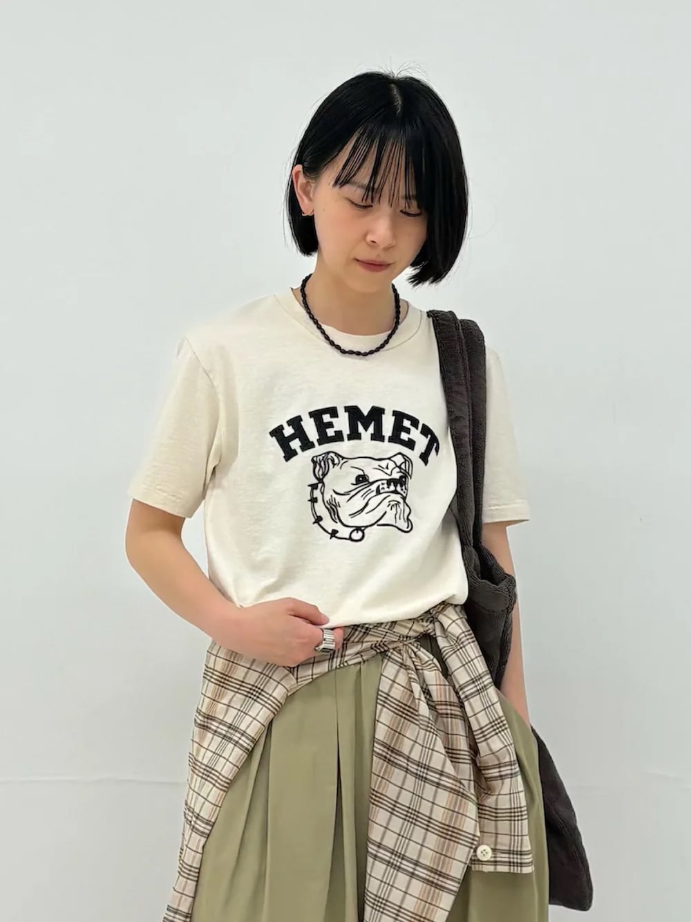 ベージュ系のTシャツ/カットソー、ベージュ系のその他パンツ、ブラウン系のトートバッグを着用したレディースの春コーディネートの2枚目の写真