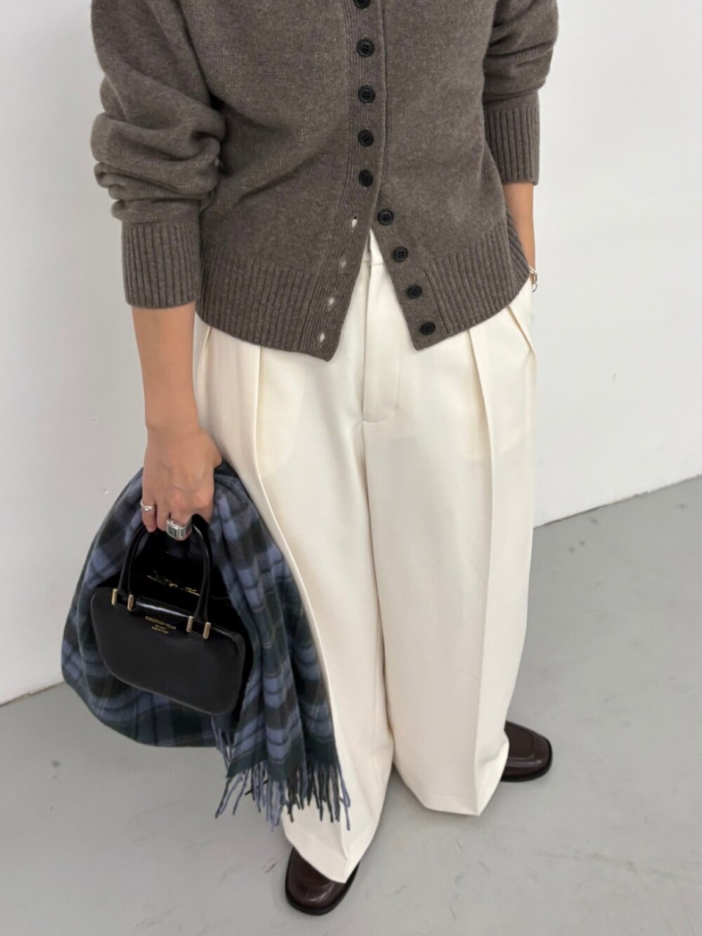 ブラウン系のカーディガン/ボレロ、ホワイト系のその他パンツ、ブラック系のショルダーバッグを着用したレディースの秋コーディネートの4枚目の写真