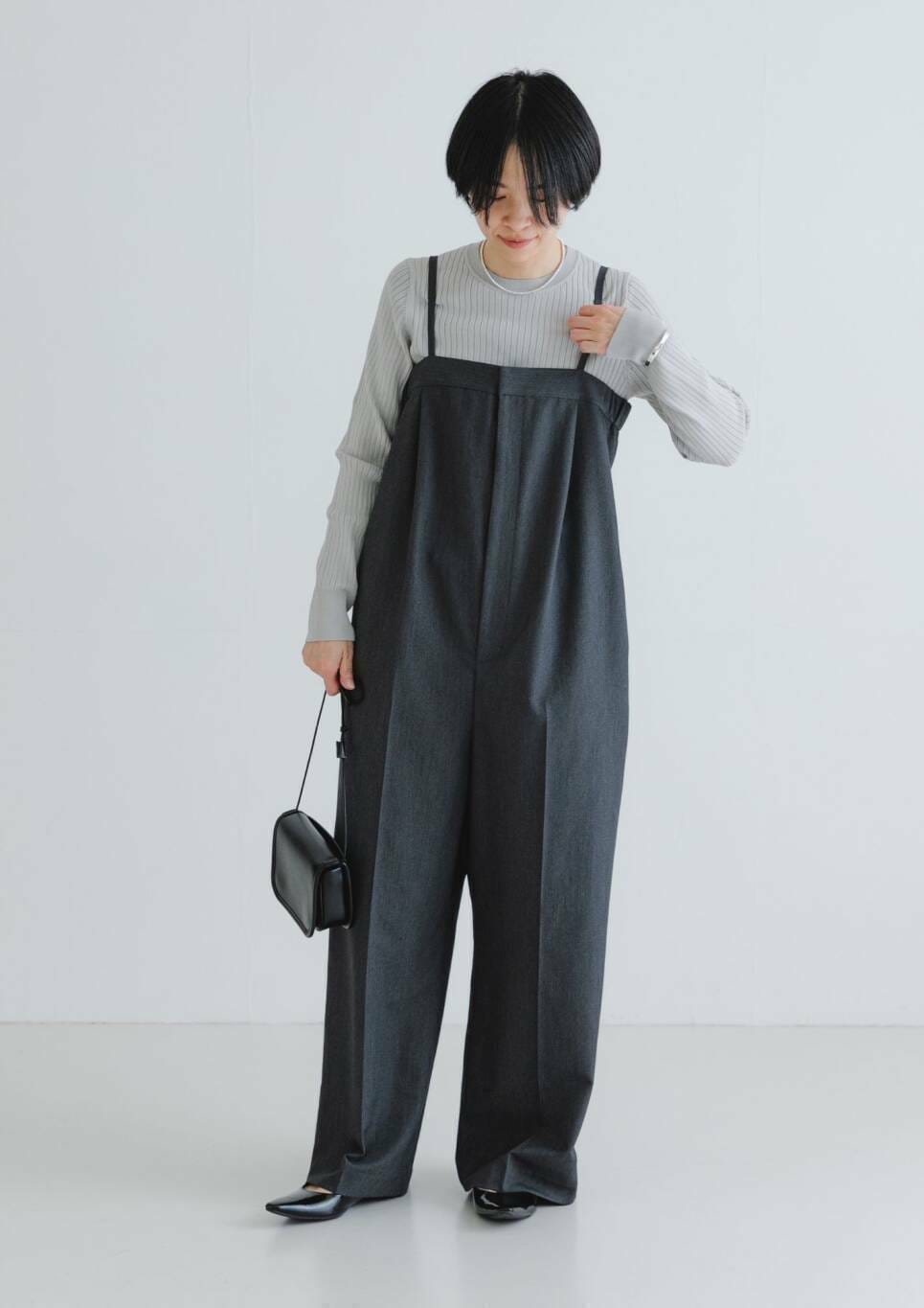 ブラック系のノーカラージャケット、ブラック系のショルダーバッグ、グレー系のサロペット/オーバーオールを着用したレディースの春コーディネートの3枚目の写真