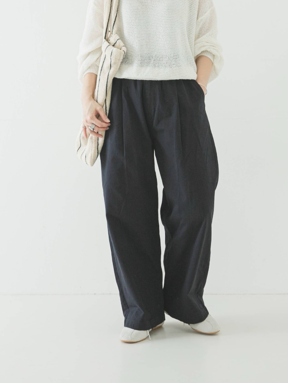 ホワイト系のニット/セーター、ホワイト系のトートバッグ、ブルー系のその他パンツを着用したレディースの春コーディネートの3枚目の写真