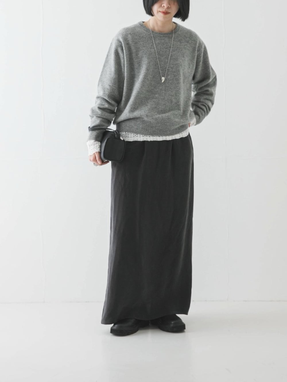 ホワイト系のTシャツ/カットソー、グレー系のスカート、ブラック系のブーツを着用したレディースの冬コーディネートの3枚目の写真