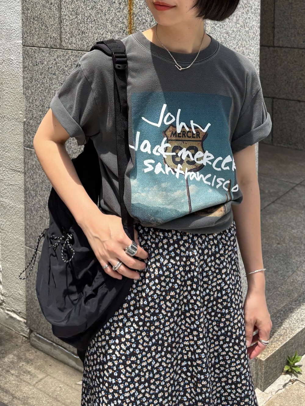 グレー系のTシャツ/カットソー、ホワイト系のスカート、ブラック系のバックパック/リュックを着用したレディースの夏コーディネートの4枚目の写真