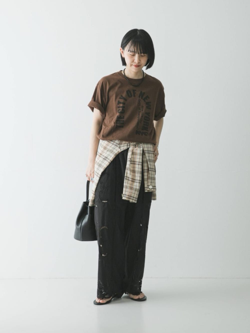 ブラウン系のTシャツ/カットソー、ブラック系のその他パンツ、ブラック系のハンドバッグを着用したレディースの春コーディネートの3枚目の写真