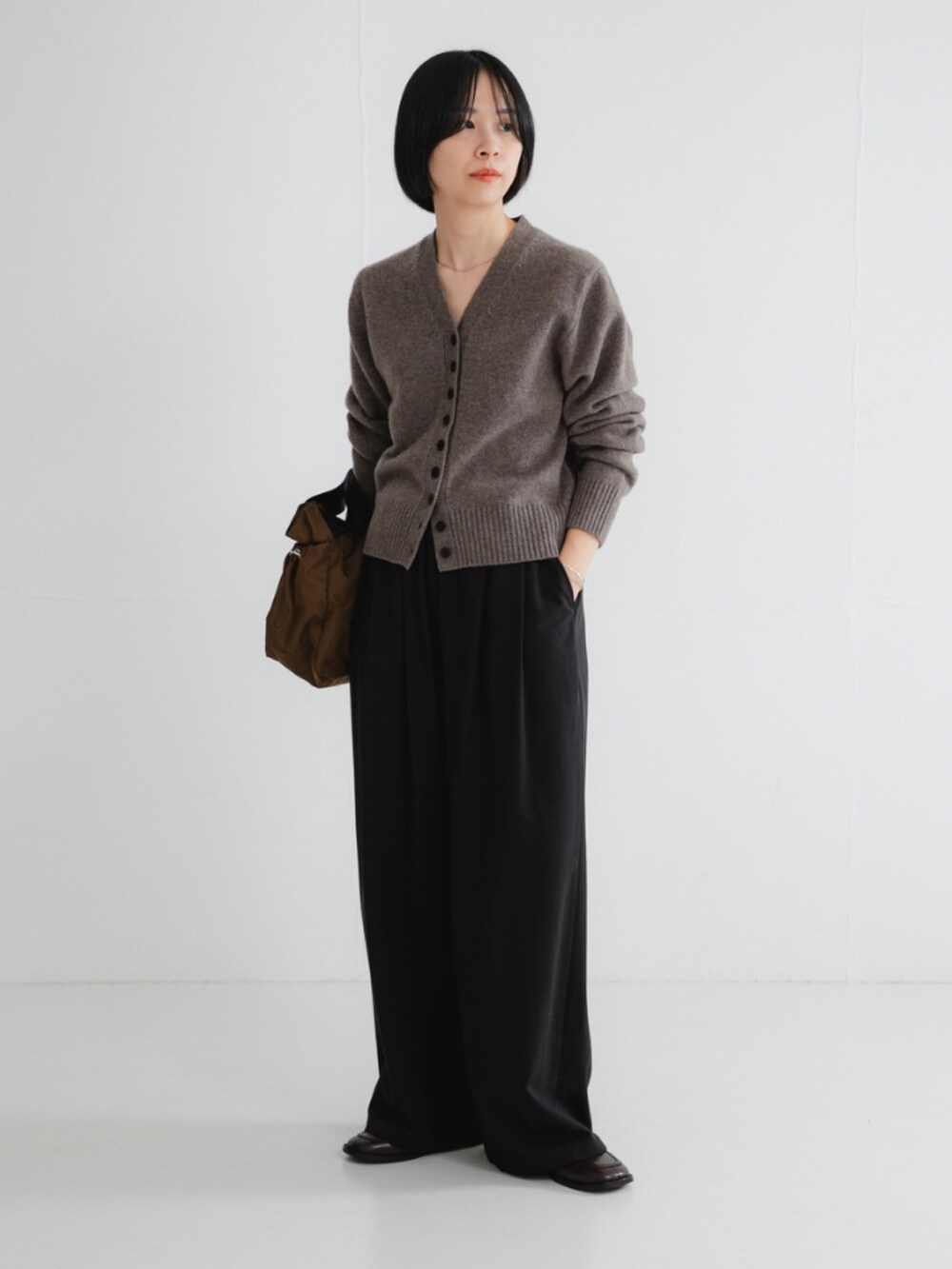 ブラウン系のカーディガン/ボレロ、ブラック系のその他パンツ、ブラウン系のショルダーバッグを着用したレディースの秋コーディネートの2枚目の写真