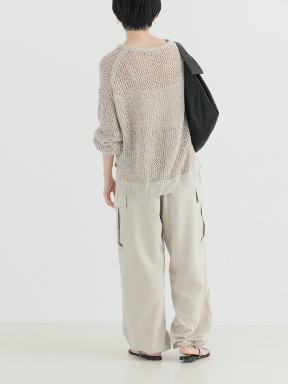 ホワイト系のニット/セーター、ベージュ系のカーゴパンツを着用したレディースの春コーディネートの2枚目の写真