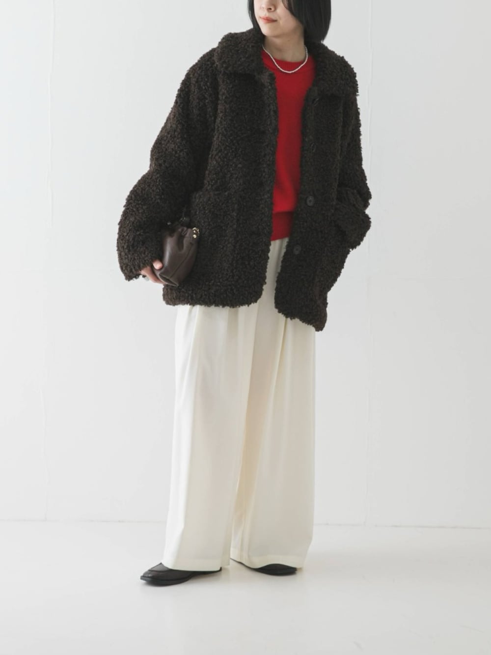 ブラウン系のその他アウター、レッド系のニット/セーター、ホワイト系のその他パンツを着用したレディースの冬コーディネートの2枚目の写真