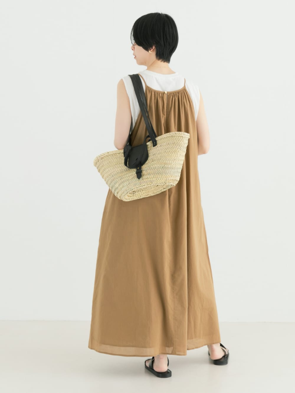 ベージュ系のワンピース、ブラック系のかごバッグを着用したレディースの春コーディネートの3枚目の写真