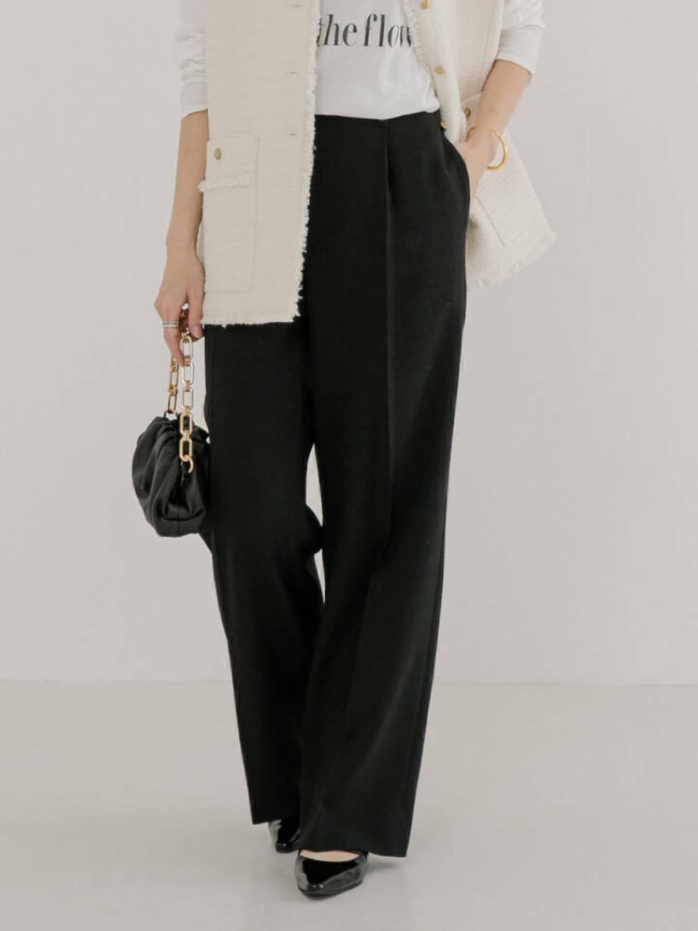 ホワイト系のTシャツ/カットソー、ホワイト系のベスト、ブラック系のその他パンツを着用したレディースの冬コーディネートの4枚目の写真