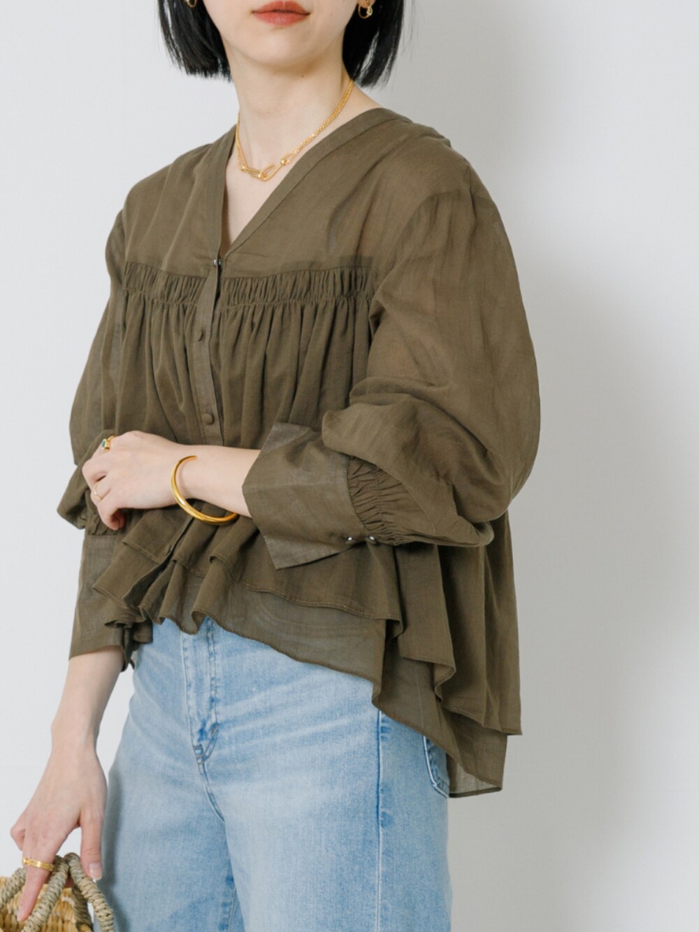 ベージュ系のシャツ/ブラウス、ブルー系のデニムパンツを着用したレディースの春コーディネートの4枚目の写真