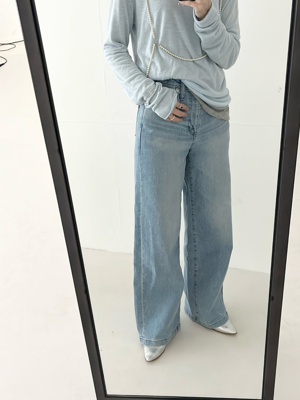 グレー系のTシャツ/カットソー、ブルー系のデニムパンツ、その他のネックレスを着用したレディースの春コーディネートの2枚目の写真