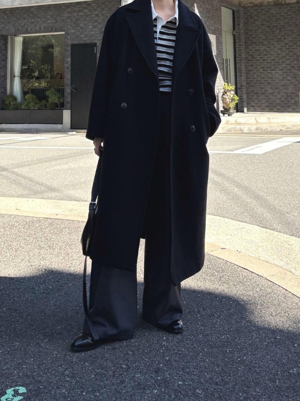 ブラック系のチェスターコート、グレー系のTシャツ/カットソー、グレー系のTシャツ/カットソーを着用したレディースの秋コーディネートの3枚目の写真