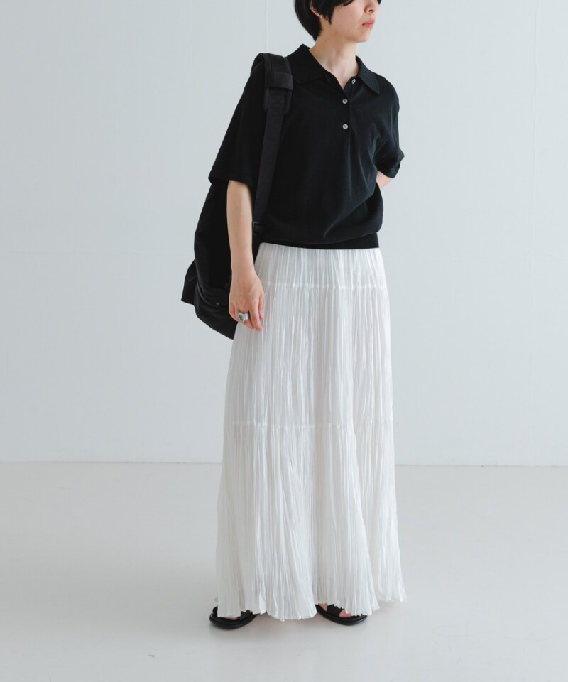 ブラック系のサンダル、ブラック系のバックパック/リュック、ホワイト系のスカートを着用したレディースの夏コーディネートの2枚目の写真