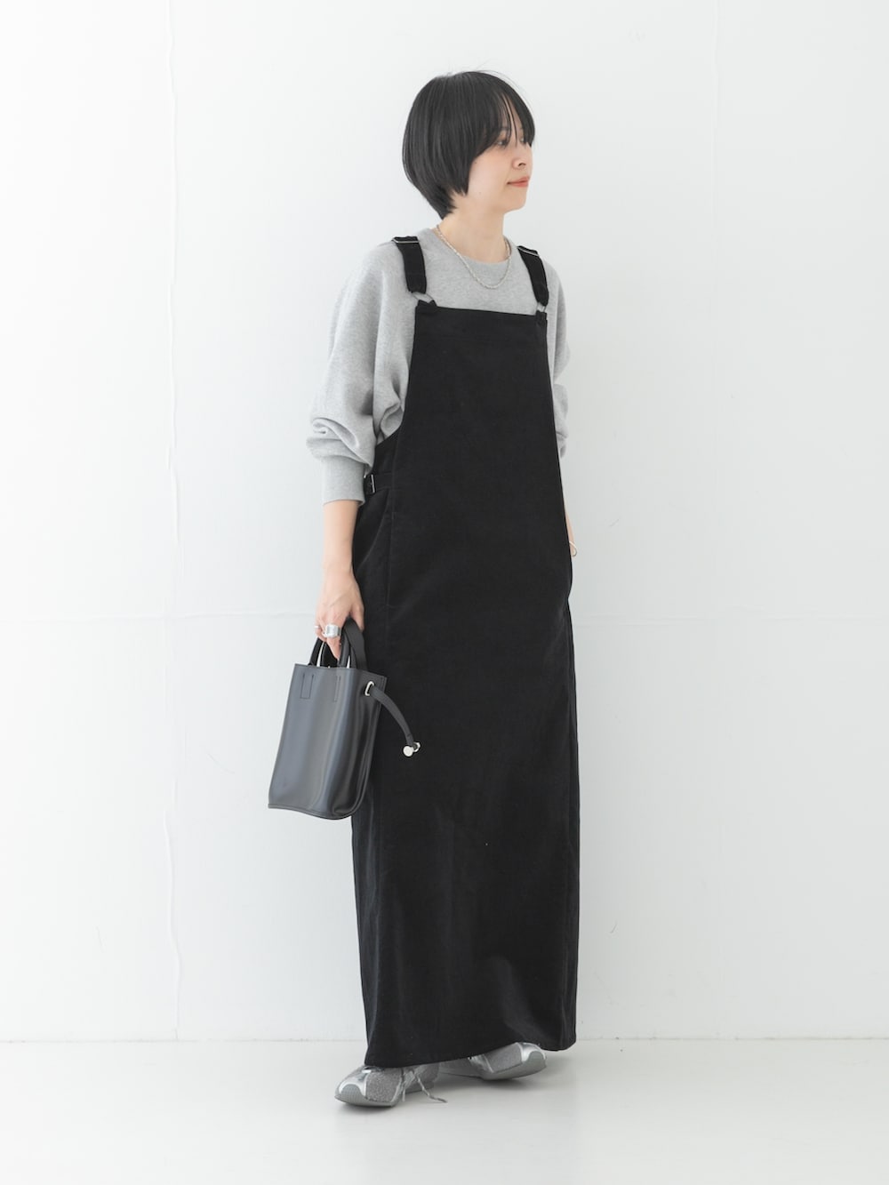グレー系のニット/セーター、ブラック系のショルダーバッグ、グレー系のスニーカーを着用したレディースの秋コーディネートの2枚目の写真