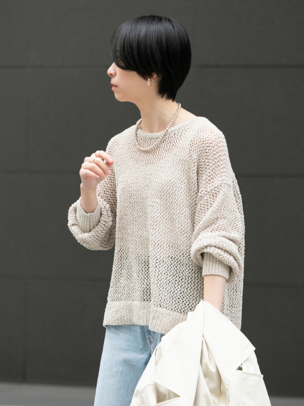 ホワイト系のニット/セーター、ブルー系のデニムパンツ、シルバー系のパンプスを着用したレディースの春コーディネートの4枚目の写真