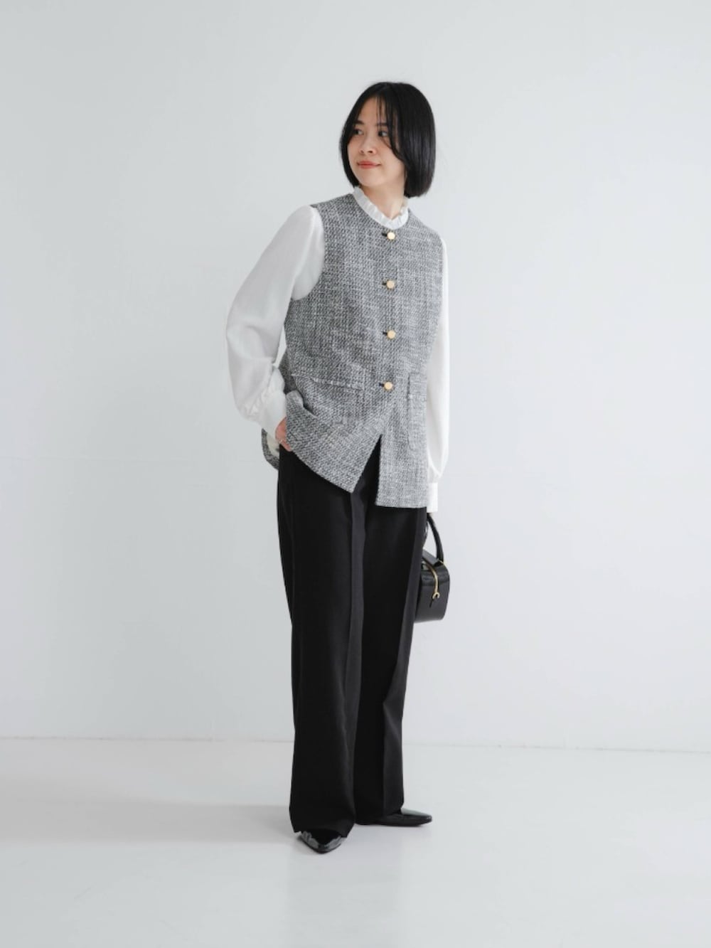 ブラック系のその他アウター、ホワイト系のシャツ/ブラウス、ブラック系のその他パンツを着用したレディースの冬コーディネートの2枚目の写真